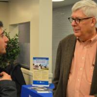 A faculty member talking to a student about his field of study at the Academic Major Fair.